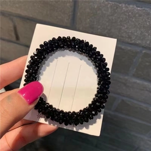Detail view of black faceted crystal bead hair tie with sparkling gemstone texture