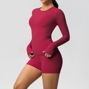 Detail of burgundy ribbed yoga set with thumbholes on long sleeves and slim-fit shorts