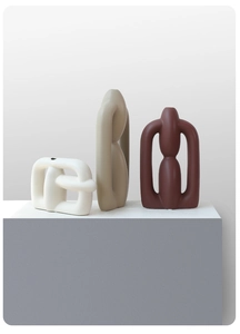 Three-piece modern geometric ceramic vases with matte finish on a minimalist pedestal