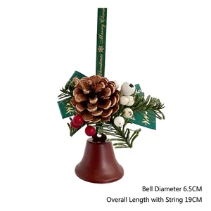 Détail d'une cloche de Noël de 6,5cm avec pommes de pin, baies et ruban Merry Christmas
