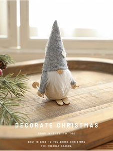 Close-up of handmade Christmas gnome on wooden skis with Nordic holiday decorations