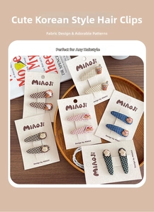 Detail of cute Korean fabric hair clips with bear and ice cream charms on plaid patterns