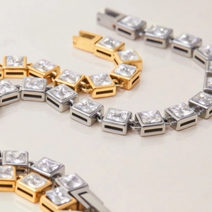 Macro detail of square-cut zircon tennis bracelets in gold and silver finishes