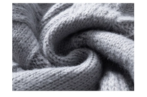 Macro shot of soft light gray cable knit fabric showing fluffy wool texture and detail