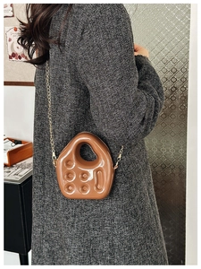 Close-up of brown glossy jelly bag with hollow texture and elegant gold chain strap