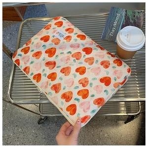 Quilted 13-14 inch laptop sleeve with colorful heart patterns on a metal cart