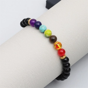Gros plan d'un bracelet chakra en pierres naturelles colorées sur un support bijoux
