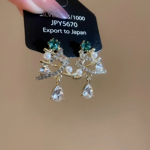 Macro detail of S925 silver Christmas tree earrings with zircon stones and pearls