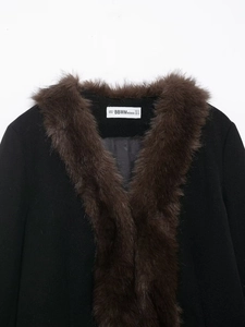 Detail shot of black coat featuring brown faux fur collar and smooth inner lining