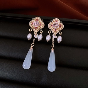 Detail of vintage flower earrings with pink crystal and white pearlescent teardrop