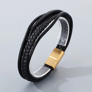 Detail of multi-layer black braided leather bracelet with golden magnetic clasp