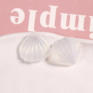 Vista macro de dijes de concha de resina blanca iridiscente para manualidades DIY