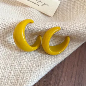 Boucles d'oreilles créoles en résine jaune vif en forme de C avec un design minimaliste