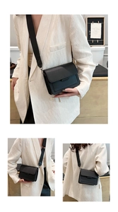 Detail view of black lychee grain leather crossbody bag with wide shoulder strap