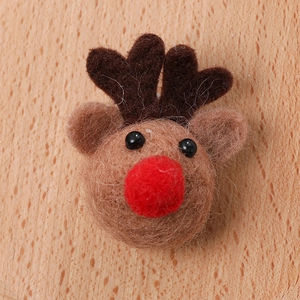 Handmade brown felt reindeer Christmas ornament on a rustic wooden table background