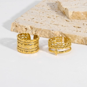 Detail of gold-plated multi-layer titanium steel rings with star charm on stone base