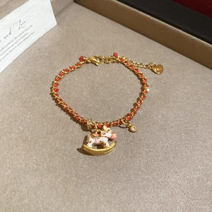 Dettaglio bracciale rosso intrecciato con ciondolo a cavallo e cuore in argento S925