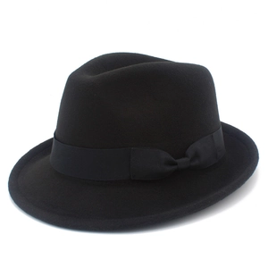 Detail of classic black wool felt fedora with matching ribbon bow and fine fiber texture