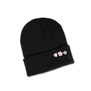 Detail view of black ribbed knit beanie with decorative heart, flower, and rhinestone pins