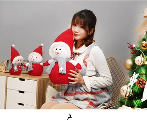 Detailed view of red plush snowman doll ornaments with soft knitted scarves and white trim