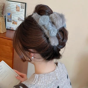 Grey plush bow hair claw clip styled on back of head with soft autumn winter textures