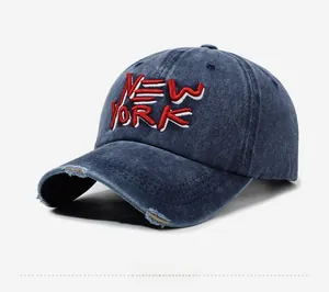 Detail of New York embroidery on washed denim baseball cap with distressed brim