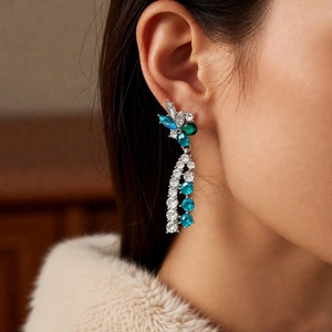 Close-up of silver tassel earrings with blue flower gemstones and crystal fringe
