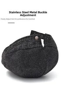 Detail of adjustable stainless steel buckle and plaid fabric on dark grey wool newsboy cap