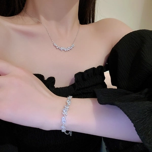Elegant silver leaf necklace and bracelet set with clear crystals worn by model