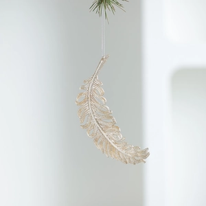 Champagne gold feather ornament hanging on a pine branch for Christmas decoration