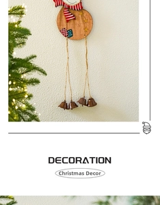Detail of wooden Christmas ornament with snowman painting and brown metal bells