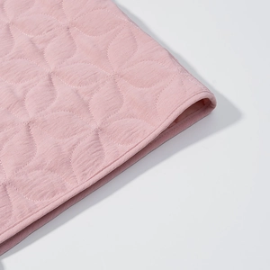 Detailed macro view of pink quilted fabric with petal pattern and high-quality edge stitching