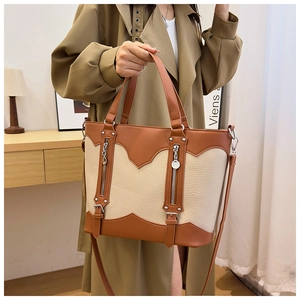 Detail of retro tote bag with brown and beige leather patchwork and metal zippers