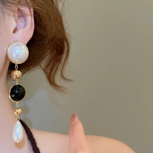 Detail of elegant 18k gold plated pearl drop earrings with black and white beads