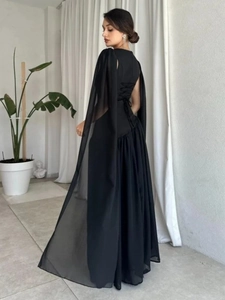 Elegant black evening gown with a flowing cape and vintage lace-up back design