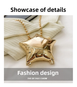 Macro detail of glossy gold star mini bag showing metal hinge and ball chain strap