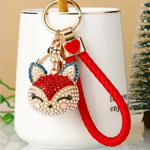 Detailed view of fox head keychain with colorful rhinestones and woven leather strap
