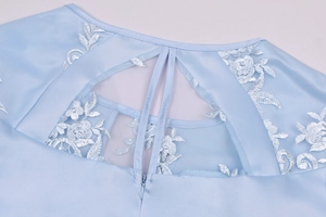 Close-up of light blue satin dress featuring floral lace embroidery and invisible zipper