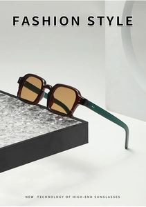 Close-up of vintage square sunglasses with tortoise frame and amber lenses on a black tray