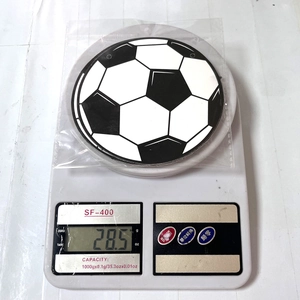 Close-up of world cup soccer themed party decoration weighing 28.5g on a digital scale