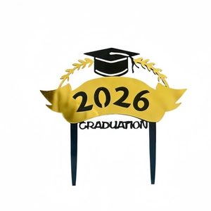 Macro shot of 2026 Graduation cake topper in gold and black metallic finish for party