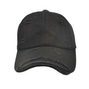 Close-up of black cotton baseball cap with distressed ripped details and worn vintage design