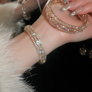 Close-up of a multi-layer gold bracelet featuring sparkling zircon and rhinestone inlay