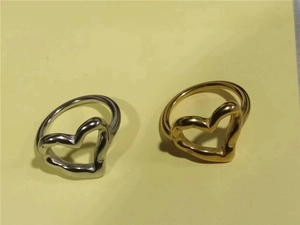 Detail of 18K gold and silver open heart rings with hammered texture design