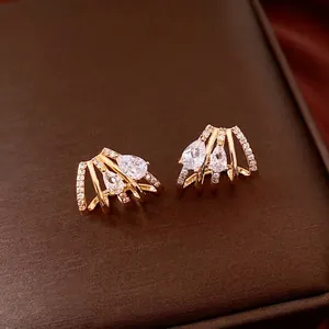 Orecchini placcati oro 14K con zirconi a goccia su espositore in pelle marrone scuro