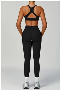 Détail d'un ensemble de yoga noir avec soutien-gorge de sport ajouré et legging taille haute