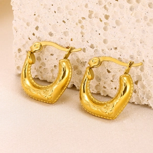 Macro shot of 18K gold plated hollow heart earrings with vintage embossed floral details
