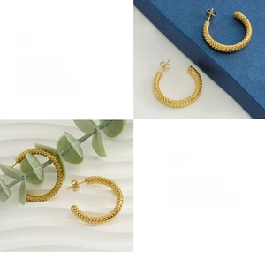 Detail of twisted rope texture and 18k gold plating on C-shaped hoop earrings