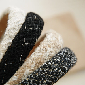 Detail of tweed hairbands in various colors showing woven texture and gold stitching