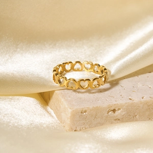 Minimalist gold titanium steel hollow heart ring on beige stone and champagne silk